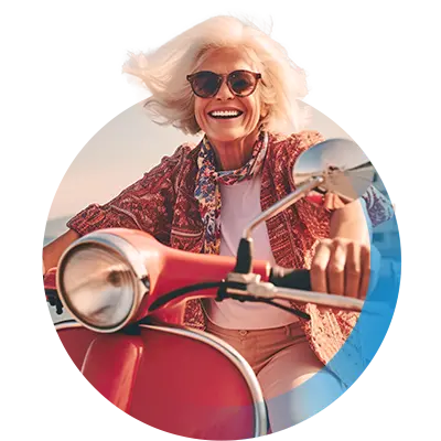 &Auml;ltere Dame mit Sonnenbrille sitzt lachend auf einem roten Motorroller.