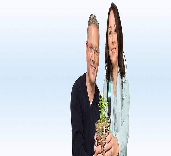 Mann und Frau halten einen Blumentopf voller Münzen - Münchener Verein Geldanlage